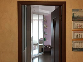 вид на угловой шкаф-купе с зеркальными дверцами гостиной с розовыми стенами, белым потолком из открытой двери прихожей с бежевыми стенами
